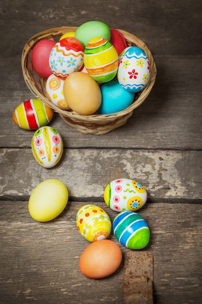 Easter eggs in the basket on wooden boards
