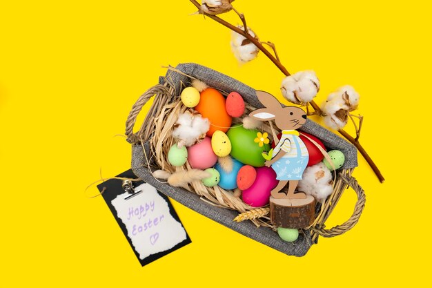 Easter Eggs in basket on yellow surface