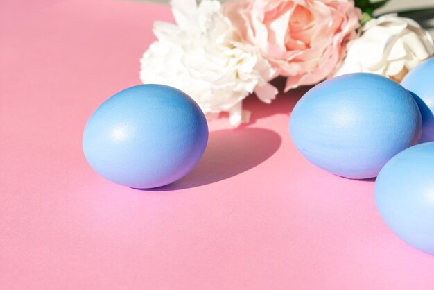 Easter eggs in blue on a pink background with flowers