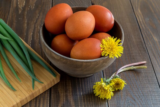 Easter eggs and a bunch of dandelions wooden table