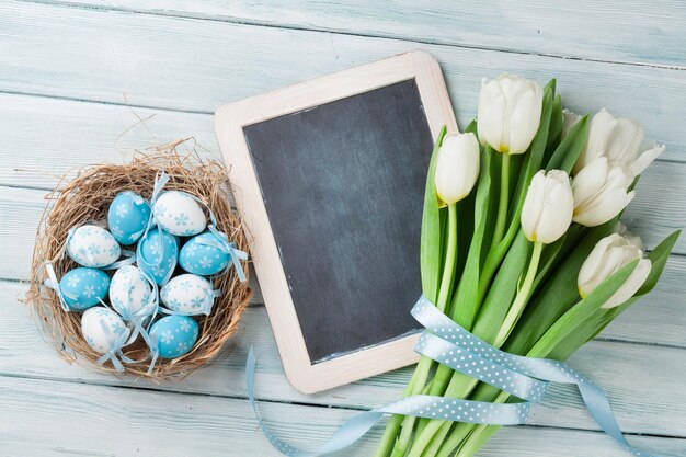 Easter eggs chalkboard and white tulips