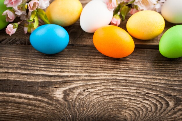 Easter eggs, cherries twigs on wooden table