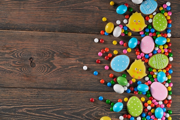 Easter eggs and chicken cookies over wooden background