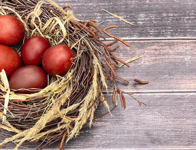 Easter eggs close-up in a bird's nest on a wooden background. Easter decor.