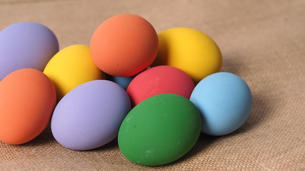 Пасхальные яйца или цветное яйцо. Разноцветные пасхальные яйца на фоне в студии с крупным планом, которые включают много цветов, таких как желтый, зеленый, синий, фиолетовый, красный, на фестивальных яйцах художественной росписью.