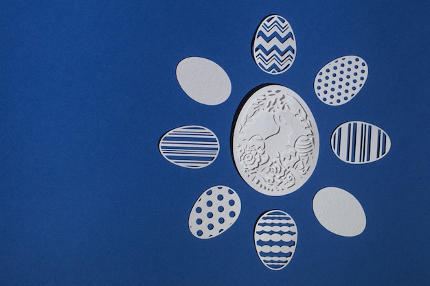 Photo easter eggs cut from paper on a classic blue background, color 2020 classic blue pantone