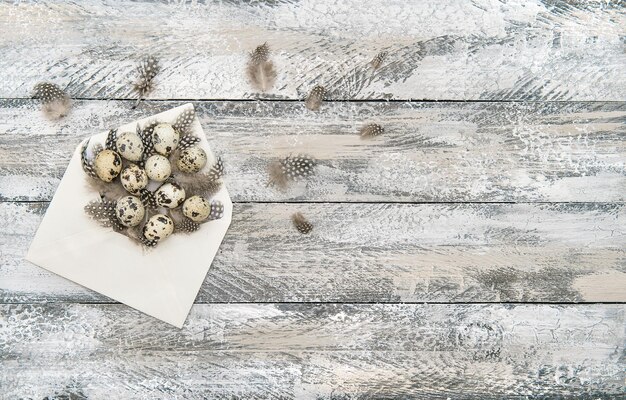 Easter eggs decoration in envelope on wooden background