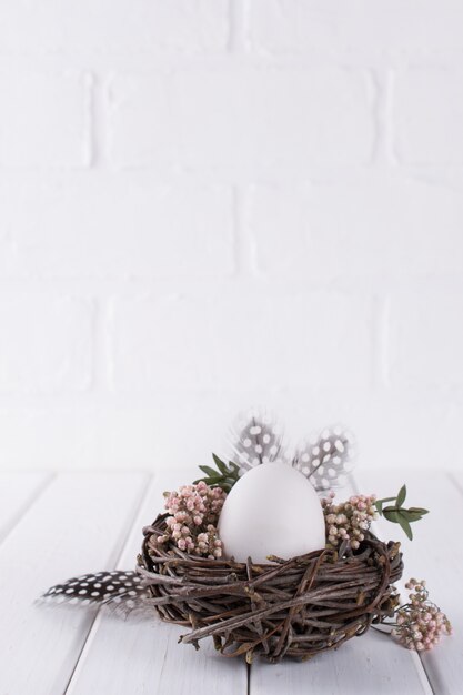 Easter eggs decoration. Nest with white chicken egg. Happy Easter  or spring greeting card