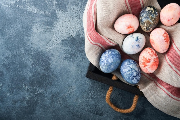 Пасхальные яйца Окрашенные пасхальные яйца с эффектом мраморного камня и синим цветом в деревенском стиле на фоне темного камня Пасхальный фон Вид сверху