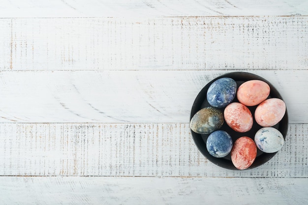 부활절 달걀 오래 된 목조 흰색 배경 부활절 배경 상위 뷰에 소박한 스타일의 대리석 돌 효과 참조 및 파란색 색상으로 염색된 부활절 달걀