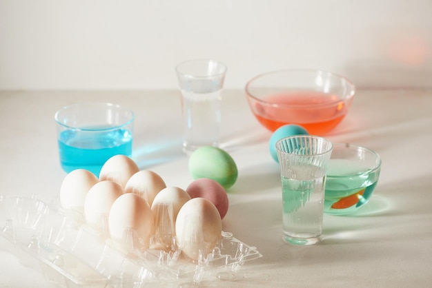 Easter eggs dyeing in glass with colors