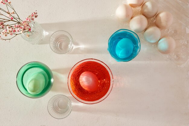 Easter eggs dyeing in glass with colors