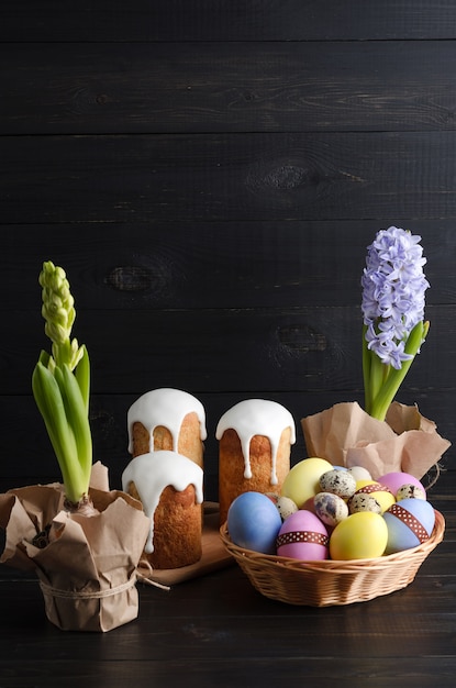 Easter eggs, easter cake and hyacinths on a dark background