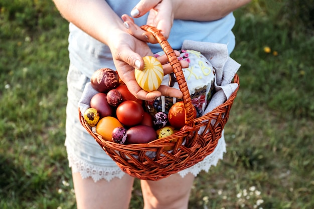 Easter eggs in female hands on bright blue background.