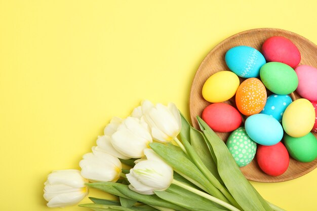 Easter eggs and flowers on the table top view