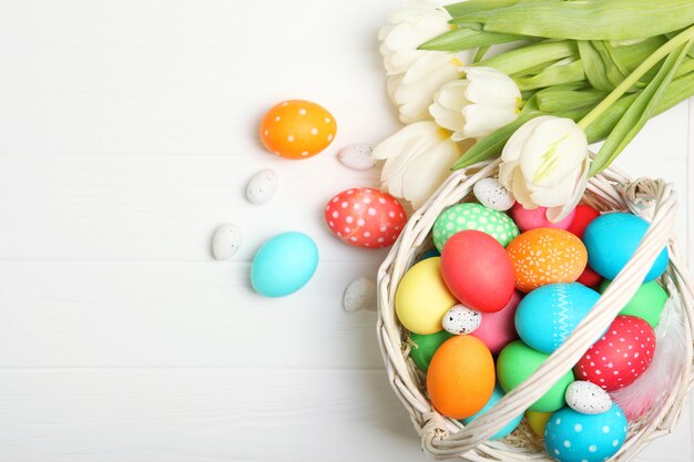 Easter eggs and flowers on the table top view