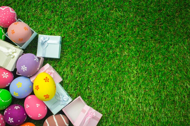 Easter eggs and gift box on the green grass background