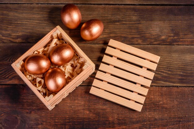 Easter eggs in gift wooden box on dark wooden table. Preparation for the holiday