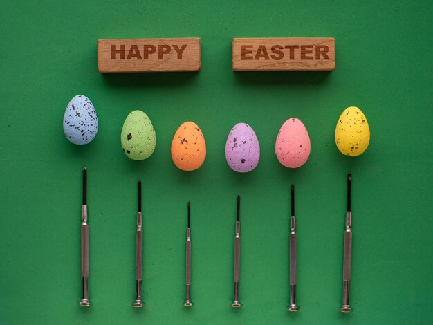 Easter eggs on green background with mini screwdrivers