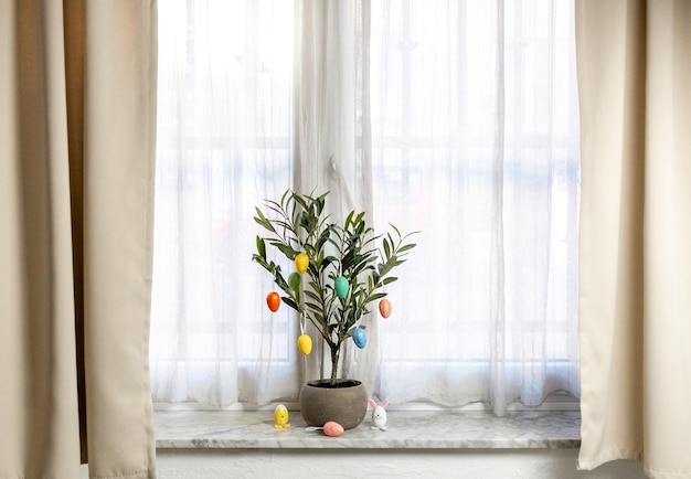 Easter eggs on green tree branches on the windowsill