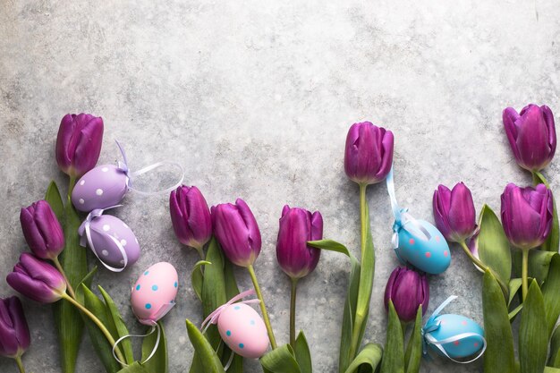 Easter eggs and lilac tulips top view flat lay