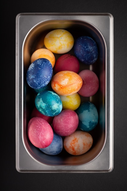 Easter eggs in a metal container close up on a black background