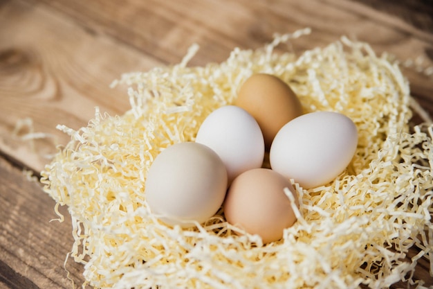 Easter eggs of natural color in a nest on a wooden background Preparation for the Easter holiday