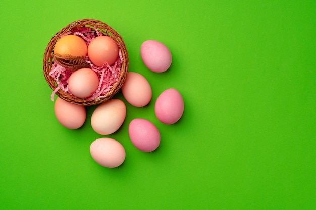 Easter eggs in a nest on green background close up