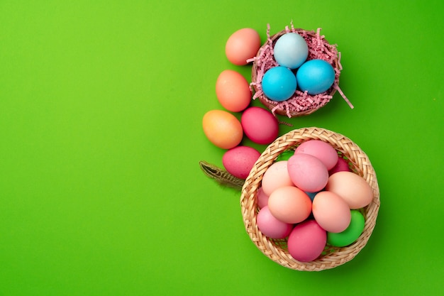 Easter eggs in a nest on green background close up