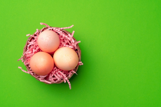 Easter eggs in a nest on green background