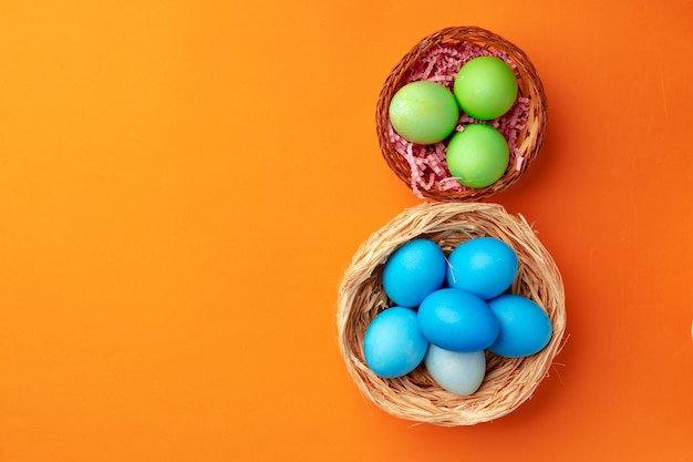 Easter eggs in a nest on orange close up