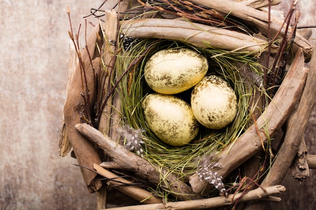 Easter eggs in the nest on rustic wooden