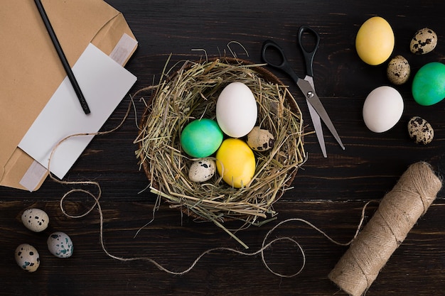 Easter eggs in nest scissors and thread on a black background