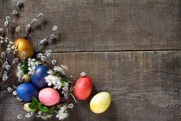 Photo easter eggs in a nest with willow branches and spring flowers top view flat lay