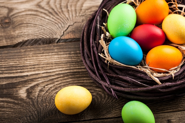 Easter eggs in a nest on wooden table