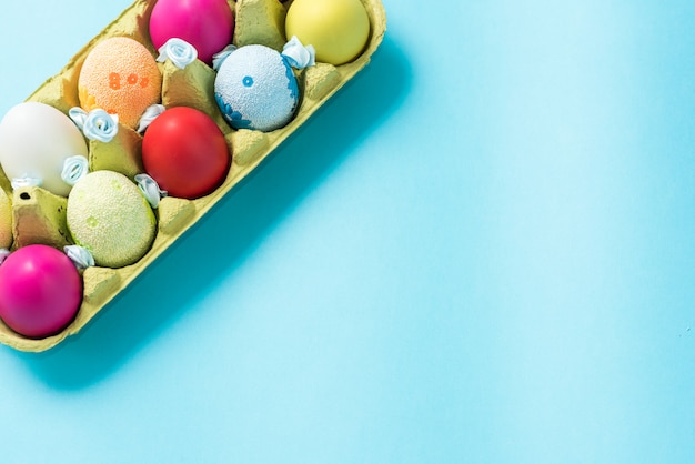 Easter eggs painted in bright colors in a carton box