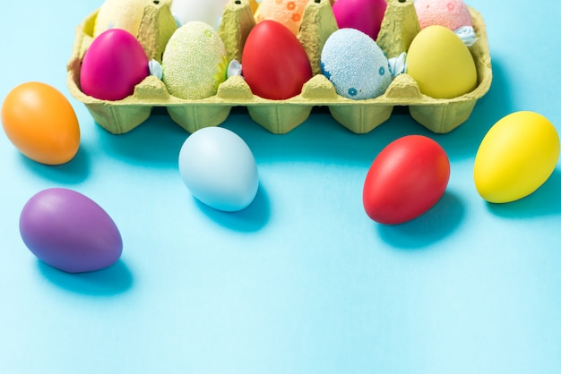 Easter eggs painted in bright colors in a carton box