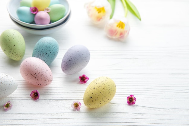 Easter eggs painted pastel colors on a white wooden background