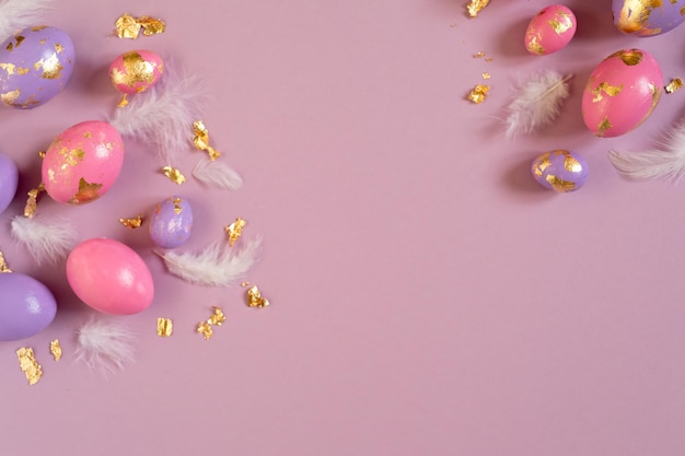 사진 보라색 배경 복사 공간에 부활절 달걀 분홍색과 보라색 황금 호일과 깃털