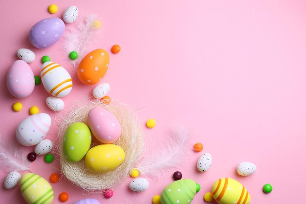 Easter eggs on a pink background with colorful candies