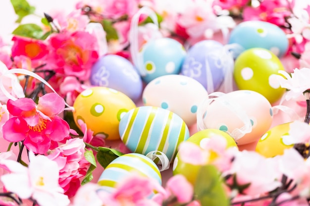 Easter eggs and pink flowers on a pink backgorund.