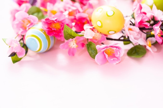 Easter eggs and pink flowers on a pink backgorund.