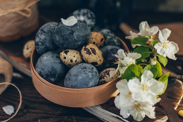 Easter eggs in the round wooden box with apple blossom branch