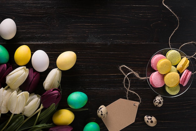 Easter eggs and tulips on dark wooden planks