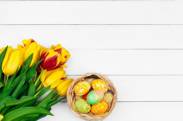 Easter eggs and tulips on wooden planks