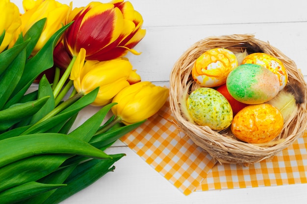 Easter eggs and tulips on wooden planks