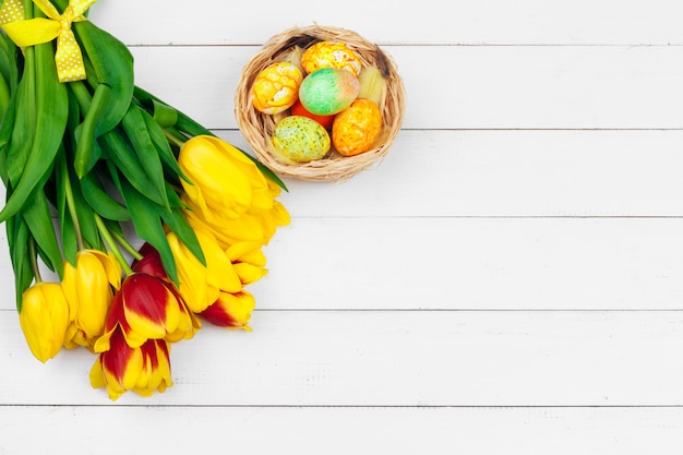 Easter eggs and tulips on wooden planks