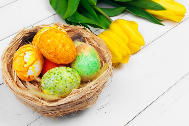 Easter eggs and tulips on wooden planks