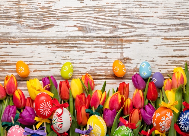 Easter eggs and tulips on wooden planks