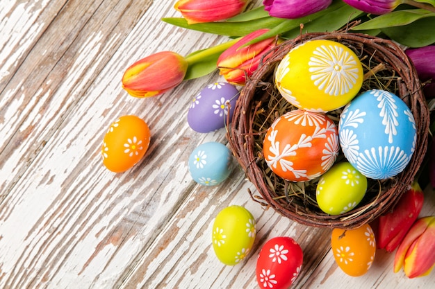 Easter eggs and tulips on wooden planks